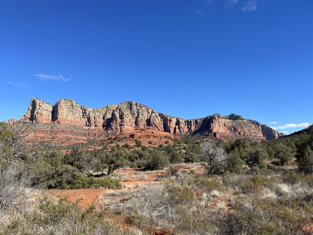 Red rock cliffs above high-desert scrub in Sedona, Arizona.