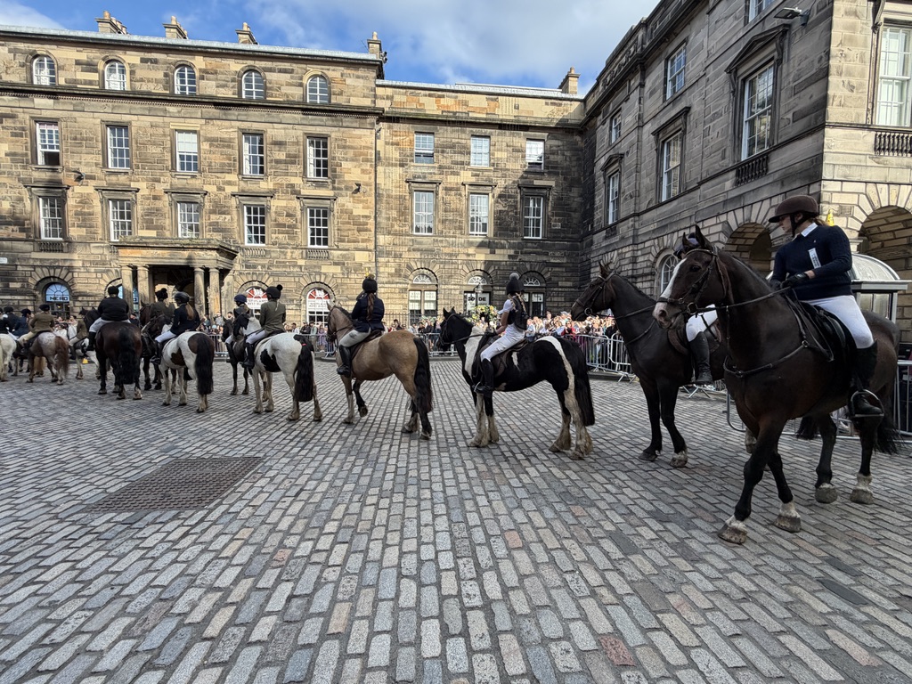 Horses and riders moving through the Ride of the Marches in Edinburgh.